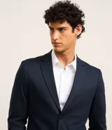 Saco de traje masculino de corte slim, confeccionado en poliviscosa con textura acanalada leve. Presenta cuello con solapa, cierre frontal con botones, mangas largas y bolsillos laterales. Incorpora tecnología performance para mayor respirabilidad y secado rápido.