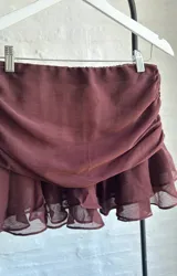 Minifalda marrón de tul con frunces laterales y volados en el ruedo.