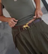 Cinturón de cuero marrón con hebilla metálica dorada en forma de caballo.