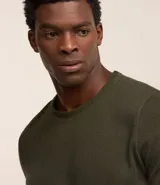 Remera de manga corta y cuello redondo, confeccionada en tejido de media malla con textura vertical. Presenta un diseño minimalista y ligero, ideal para un uso versátil y cómodo.