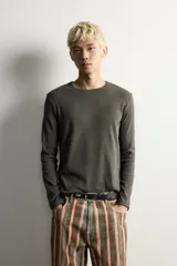 Camiseta de manga larga con cuello redondo, confeccionada en tejido con estructura de canalé y corte relajado.