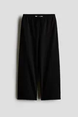 Pantalón jogger negro de felpa liviana, con cintura elástica, cordón ajustable, bolsillos laterales y diseño de perneras amplias con bajo enrollado.