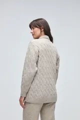 Trench de lana fina sin teñir, con diseño de textura combinada. Presenta mangas y espalda tejidas con patrón de trenzas, cuerpo liso, cuello camisero, cierre frontal con botones y bolsillos delanteros funcionales.