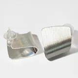 Aros de plata con forma geométrica irregular con textura cepillada.