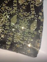 Vestido corto negro con bordados dorados y lentejuelas, escote en V profundo y breteles finos. Espalda descubierta.