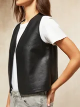 Chaleco negro de cuero sintético con escote en V y corte recto.