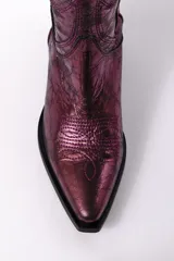 Bota alta estilo cowboy color dorado metalizado, con bordados decorativos y puntera en punta.