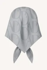 Pañuelo cuadrado grande de satén color gris claro, con estampado en tono más oscuro del logo de la marca (letras 'A' y 'D' entrelazadas).
