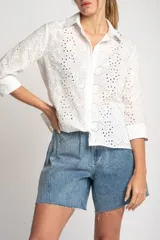 Camisa blanca de algodón con bordado calado tipo broderie, corte recto, cuello camisero y mangas 3/4.