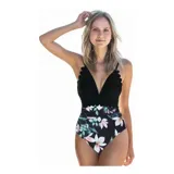 Malla enteriza bicolor de diseño combinado, con parte superior lisa en color negro de escote en V pronunciado con bordes ondulados, y parte inferior con estampado botánico de hojas verdes y flores rosadas sobre fondo negro. Cuenta con tirantes finos regulables.