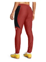 Pantalón deportivo Under Armour de corte ajustado, diseñado para fútbol. Presenta un diseño bicolor en rojo y negro con cintura elástica y cordón de ajuste interno. Incluye tecnología de secado rápido y tejido elástico en cuatro direcciones para mayor movilidad.