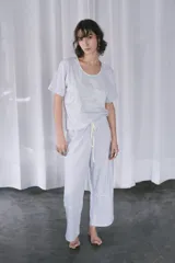 Pijama de algodón gris melange, compuesto por una remera de manga corta con bordado a contratono en color limón y un pantalón largo holgado con cordón de ajuste en la cintura.