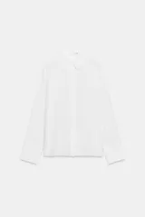 Camisa de lino de corte clásico con cuello solapa, manga larga con puños anchos y cierre frontal con botones.