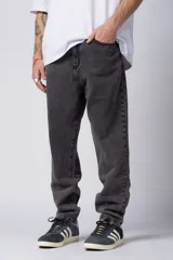 Jean de corte mom fit en color gris oscuro con efecto lavado, confeccionado en denim resistente. Presenta un diseño de tiro medio con ajuste relajado en la cadera y piernas ligeramente entalladas hacia el tobillo.