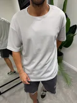 Remera de corte oversize confeccionada en tejido tipo waffle, con cuello redondo y mangas cortas.