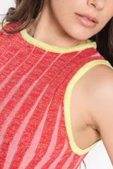 Vestido corto de punto con brillo, de rayas verticales rojas y rosadas, cuello redondo y diseño sin mangas.