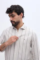 Camisa de manga larga con diseño de rayas verticales, confeccionada en mezcla de lino y algodón, con cuello camisero y cierre frontal de botones.