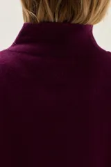 Polera de tejido de punto color azul, con cuello alto, manga larga y puños acanalados.