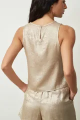 Blusa plateada sin mangas con textura brillante.