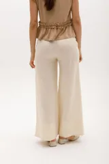 Pantalón palazzo color coral de lino con cintura alta y bolsillos laterales.