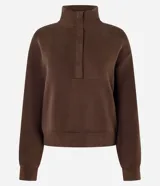 Buzo de modal color marrón, de manga larga, con cuello alto estructurado y cierre frontal parcial con cremallera. Presenta diseño confortable con costuras pespunteadas en el frente y puños y ruedo ajustados.