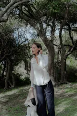 Camisa blanca de 100% algodón con cuello mao, escote en V y detalles de bordado en la parte frontal y puños.