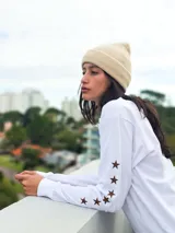 Remera de manga larga color blanco, con estampado frontal con la frase 'Style Club' y estrellas pequeñas en las mangas.