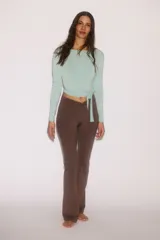 Top cropped de yoga color menta de manga larga, confeccionado en punto modal suave, con escote en V pronunciado y tiras para anudar al frente.