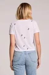 Remera blanca de lino con estampado de pequeños caballos, cuello redondo y mangas cortas.