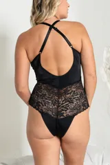 Body negro de lycra y microtul con patrón de puntos, con puntilla elastizada, tiras cruzadas en la delantera, breteles elásticos regulables y broche en la entrepierna.