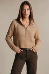 Sweater de punto acanalado color camel, con cuello alto y cierre frontal parcial. Presenta mangas largas con diseño raglán y un corte ligeramente cropped.