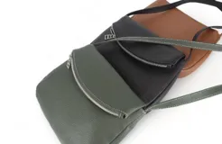 Bandolera negra de cuero con correa larga regulable, solapa con cierre de cremallera y cierre magnético.