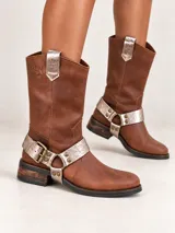 Botas estilo cowboy de cuero marrón, de caña media, con estribo desmontable plateado texturizado y hebilla metálica.