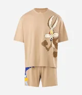 Pijama corto de algodón en color beige, compuesto por remera de manga corta con corte boxy y gran estampa frontal del Coyote de Looney Tunes, y bermuda haciendo juego con estampado lateral.