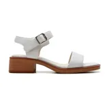 Sandalias blancas de cuero con dos tiras, una sobre los dedos y otra al tobillo con hebilla metálica. Taco bajo de madera.