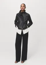 Pantalón de tiro medio color negro, de diseño recto y largo, con trabillas en la cintura, dos bolsillos laterales y cierre oculto con botón, gancho y cremallera.