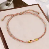 Set de collares cortos con cordones trenzados de múltiples colores y dijes cilíndricos con inscripciones y detalles esmaltados.