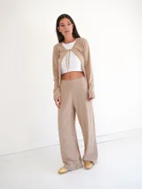 Pantalón de tiro medio con silueta recta y leve amplitud, confeccionado en tejido suave de caída fluida y cintura limpia sin cierre visible.