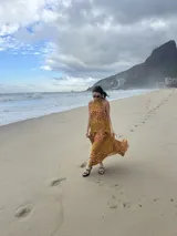Vestido largo marrón de crepe texturizado, con cuello halter fruncido, diseño holgado y falda larga con vuelo.