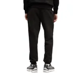 Pantalón de jogging Puma Essentials, color negro, con cintura elástica, puños acanalados y logo de la marca estampado en el muslo izquierdo.