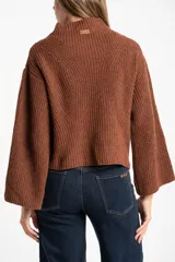 Polera de lana color marrón, con cuello alto, diseño acanalado y corte oversize con mangas anchas.