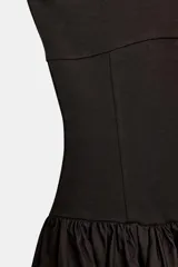Vestido midi negro con escote asimétrico de un solo hombro, cuerpo ajustado y falda amplia de corte asimétrico con frunces en la cintura.