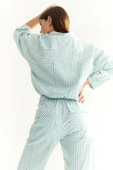 Buzo de corte oversized a rayas grises y blancas, con cuello polo y mangas largas con puños elásticos.