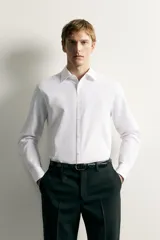 Camisa negra de corte regular fit, cuello italiano, manga larga con puño abotonado y cierre frontal con botones.