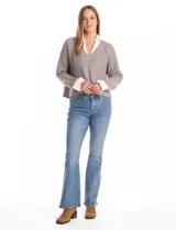 Buzo de tejido de punto acanalado color gris, con escote en V y lentejuelas incrustadas. Presenta un efecto combinado con cuello y puños de camisa blanca asomando por debajo.