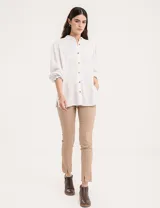 Blusa celeste de cuello mao y mangas abullonadas con puños elásticos. Tiene tajos laterales y botones en la delantera.