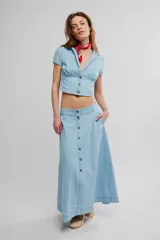 Conjunto de dos piezas de denim celeste, compuesto por un top corto de mangas cortas con escote en V y botonadura frontal, y una falda midi abotonada al frente.