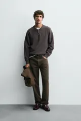 Jersey de punto de algodón con corte relajado, cuello en pico con cierre frontal de botones y manga larga con puños y bajo en rib.