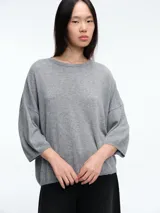 Sweater de tejido de punto en color gris, con cuello redondo y mangas tres cuartos de corte holgado.