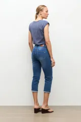 Jean capri de corte ajustado y tiro medio, en tono azul medio, con dobladillo vuelto en los bajos y bolsillos clásicos.